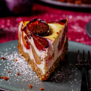 Ein Stück Zwetschgen-Topfenkuchen auf Teller (Close-up).